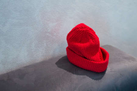 A red woolen winter hat on a sofaの写真素材