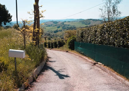 A white mailbox on the side of the roadの写真素材