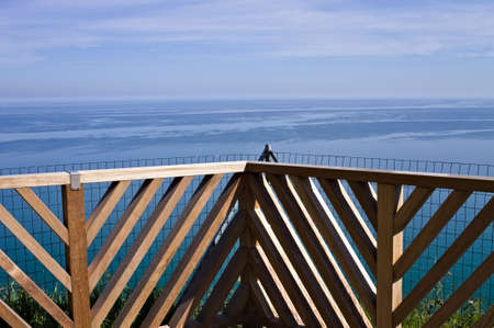 A breathtaking view of the Mediterranean sea from a balcony with a wooden railingの写真素材