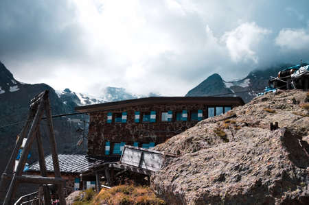 A stone mountain hut in the Italian Alps behind a rock (Trentino, Alps, Italy, Europe)の写真素材
