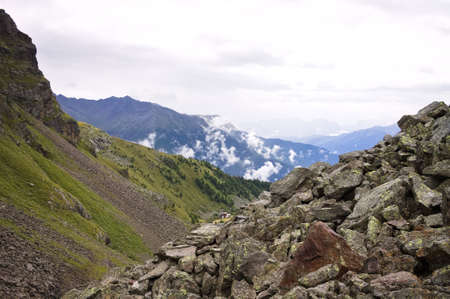 A pile of rocks in the Italian Alps with a view of the mountains and the valley in background (Trentino, Italy, Europe)の写真素材
