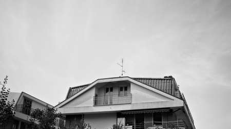 Italian residential building with prismatic roof finished with tiles and balconies (Marche, Italy, Europe)の写真素材