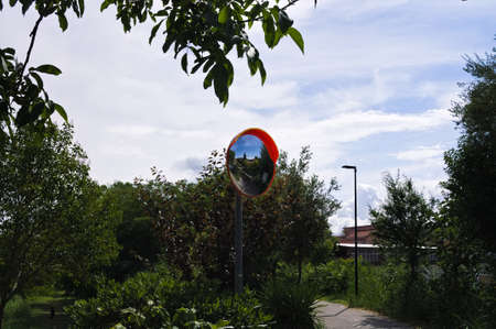 An orange plastic traffic mirror on a bike path (Marche, Italy, Europe)の写真素材