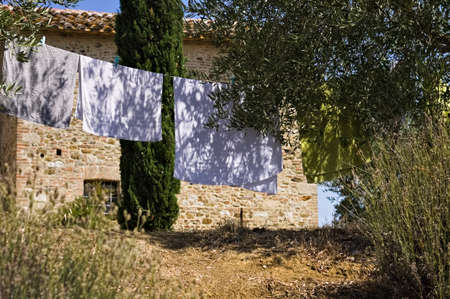 Towels and clothes hanging out to dry in the garden of a farm in the Italian countryside (Tuscany, Italy, Europe)の写真素材