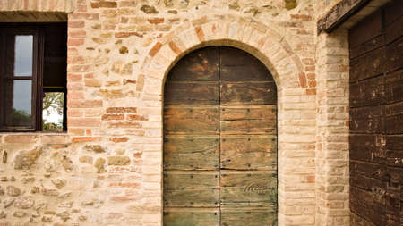 A rustic wooden green door in a stone cottage in the Italian countryside (Umbria, Italy, Europe)の写真素材