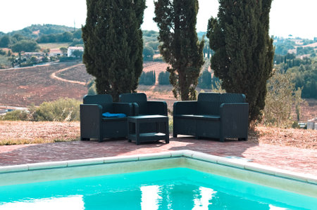 Outdoor sofas under cypress trees near the pool (Umbria, Italy, Europe)の写真素材