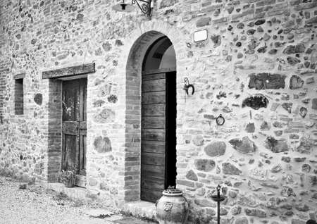 The facade of a rural stone farmhouse with wooden doors and windows in the italian countryside (Tuscany, Italy, Europe)のeditorial素材