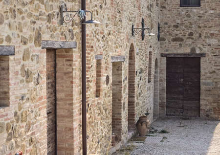 The facade of a rural stone farmhouse with wooden doors and windows in the italian countryside (Tuscany, Italy, Europe)のeditorial素材