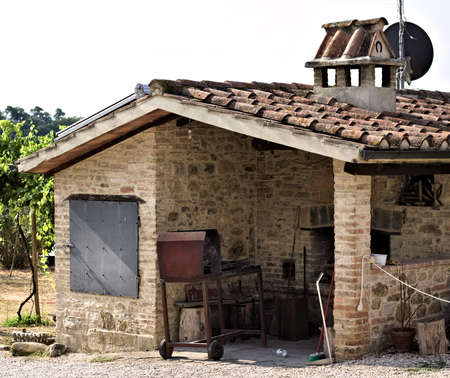 A stone oven with iron utensils for grilling meat with roof tiles and bricks in a farmhouse (Umbria, Italy, Europe)の写真素材