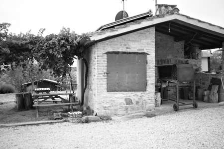 A stone oven with iron utensils for grilling meat with roof tiles and bricks in a farmhouse (Umbria, Italy, Europe)の写真素材