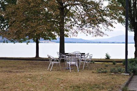 Metal table and chairs in a public park on Lake Trasimeno (Umbria, Italy, Europe)の写真素材