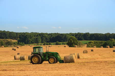 Roscoe, Missouri7/23/2017John Deere Tractor in a hayfield ready to lift a bale of hay.  Hay is used to feed to livestock.のeditorial素材