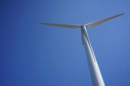A wind turbine with blue sky in a sunny day.の写真素材