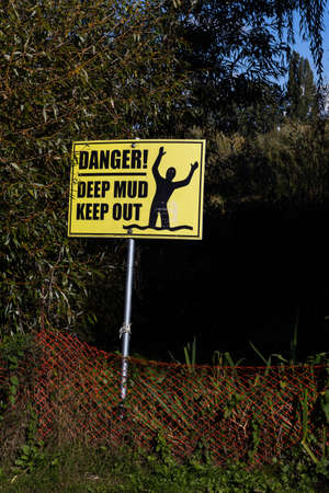 A warning sign with the inscription: Deep mud keep outの写真素材