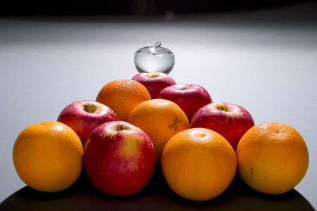 a pyramid of apples oranges and glass appleの写真素材