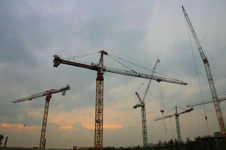 construction cranes at sunset