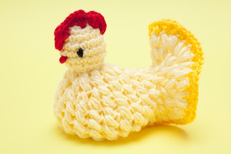 Easter decorations - hand made yarn chicken on a yellow backgroundの写真素材