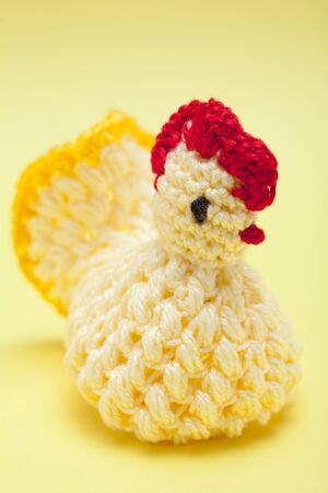 Easter decorations - hand made yarn chicken on a yellow backgroundの写真素材
