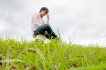 happy young man rest on the grass fieldの写真素材