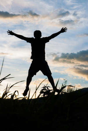 Happy man silhouette on the sunset の写真素材