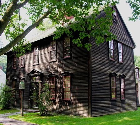 Colonial home in the shade of a tree.の写真素材