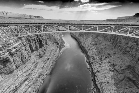 Classic black and white image of the Navajo Bridge crossing the Colorado River in the arid, desert landscape of Arizona.の写真素材