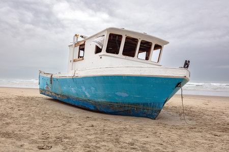 Old fishing boat on a sandy beach on the central Oregon Pacific coast, USA.の写真素材