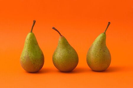        Three pears on orange background                        の写真素材