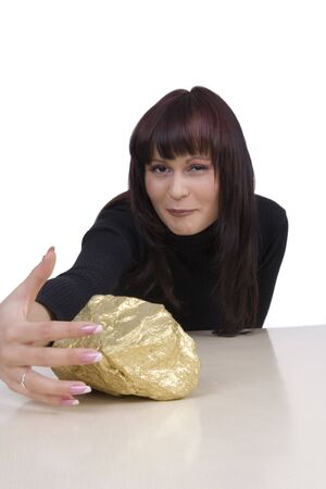 Woman with a gold nugget against a white backgroundの写真素材
