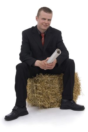 Businessman sitting on parcel straw against a white background の写真素材