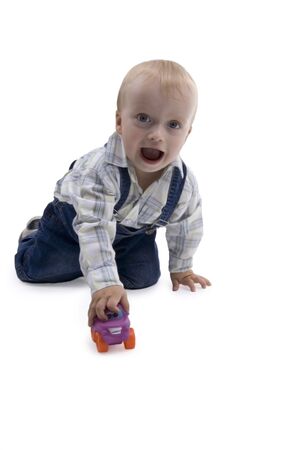 Merry boy playing with toy - car on white backgroundの写真素材