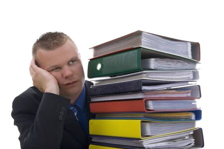Man stashed  behind folders,with frown,against a white background. の写真素材