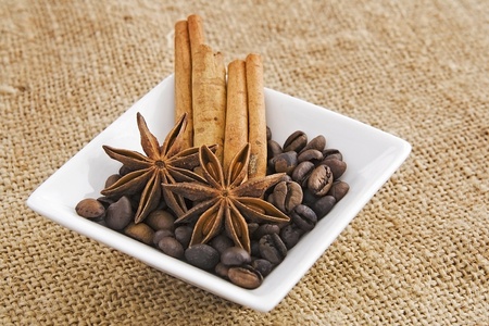 Coffee and spice in saucer  against a background from jute. 