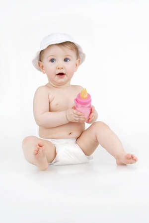 Beautiful infant in white hat with sweetness milks on white background.の写真素材