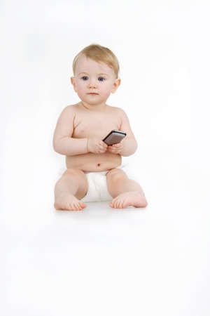 Infant on white background holds in hands mobile phone.の写真素材