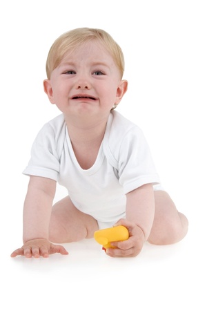 Crying infant with toy on white background.の写真素材