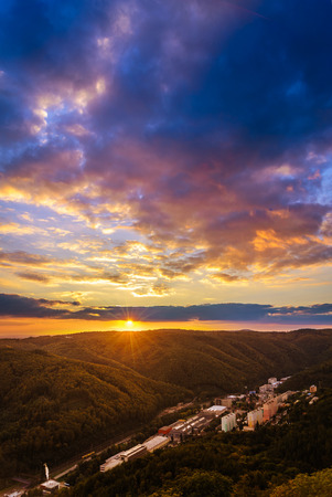 Sunset with clouds over a small city hidden in valleyの写真素材