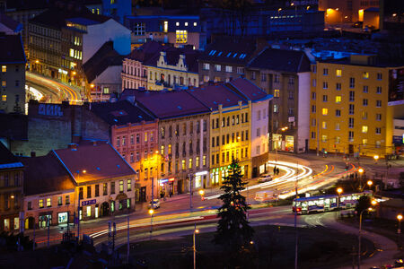 City square at night with heavy traffic and public transport