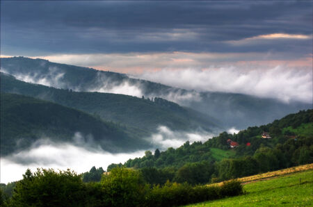 Morning in mountains with fog and clouds during sunriseの写真素材