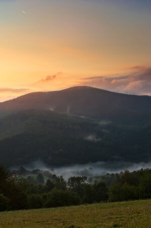 Morning in mountains with fog and clouds during sunriseの写真素材