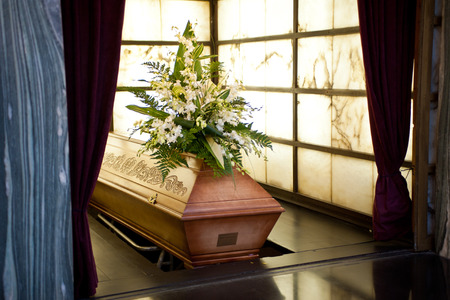 Wooden coffin with funeral flowers in crematoriumのeditorial素材