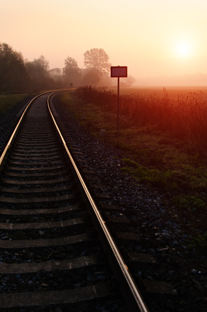 Railroad track during autumn foggy morning in countrysideの写真素材