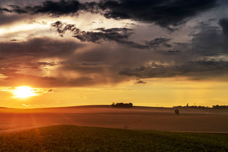Sunset in fields in Central Europe with heavy cloudsの写真素材