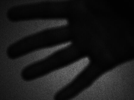 Artistic shadow of a hand in backlight against a wall - Black and white picture - France.の写真素材