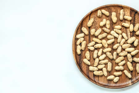 Roasted peanuts on wooden dish and white backgroundの写真素材