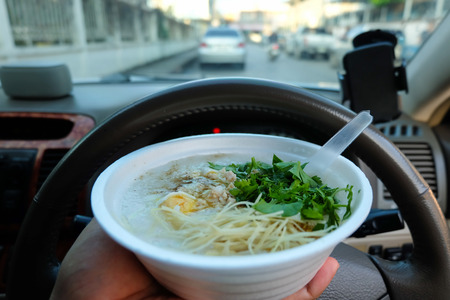 Life in a hurry, eating rice porridge behind steering wheel