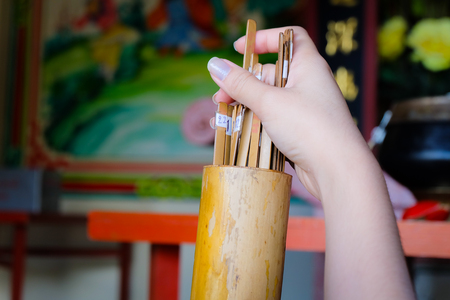 Hand catch fortune sticks in bamboo cylinderの写真素材