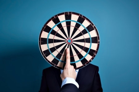 hand pointing at darts on light blue background.の写真素材