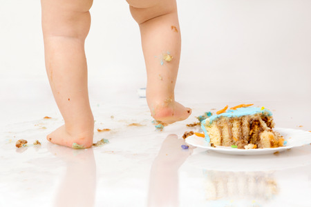 Little baby boy with birthday cake, smashing itの写真素材