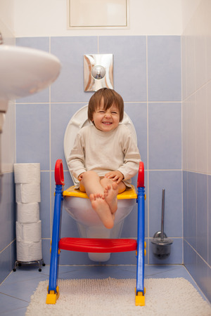 Little boy, sitting on the toiled, laughingの写真素材